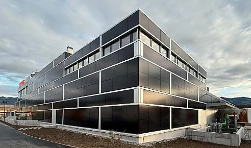 Dunkle PV-Fassade eines mehrgeschossigen Gebäudes mit horizontalem Modulraster